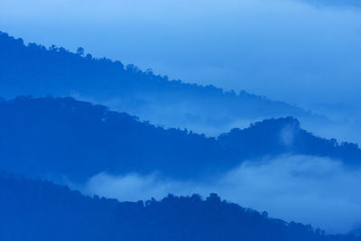 Scenic view of mountains against blue sky