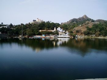 Scenic view of lake by mountains against clear sky