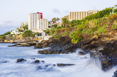 Waves on coastline in front of buildings