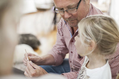 Grandfather and granddaughter playing card puzzle game at home