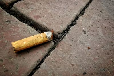 High angle view of cigarette smoking on footpath
