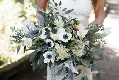 Midsection of woman with white flowering plant