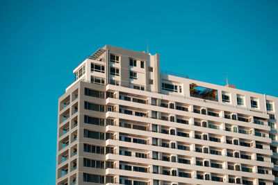 Low angle view of modern building against clear blue sky