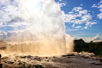 Scenic view of waterfall against sky