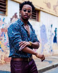 Young man standing against building