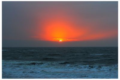 Scenic view of sea against orange sky