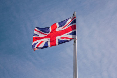 Low angle view of flag against blue sky