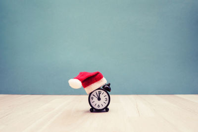 Red toy on table against blue wall