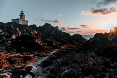 Rock formations by sea against sky during sunset