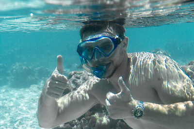 Portrait of shirtless man swimming in pool