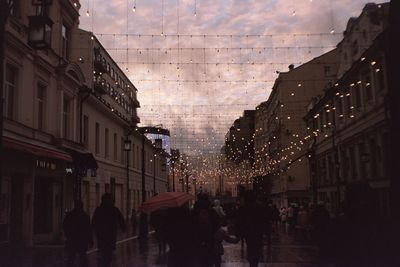 People walking on street amidst buildings in city