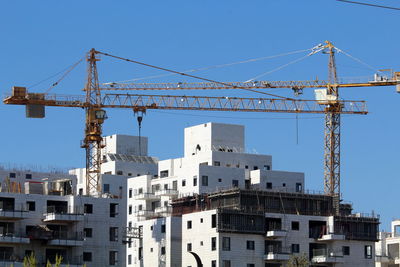 Building and construction cranes against blue sky