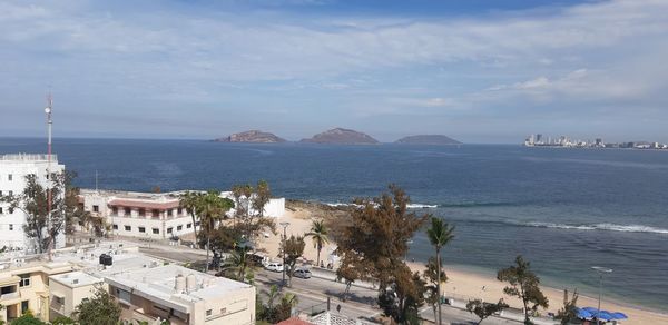 High angle view of sea and buildings against sky