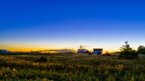 Built structure on field against clear sky at sunset