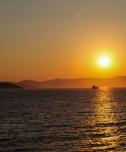 Scenic view of sea against dramatic sky during sunset