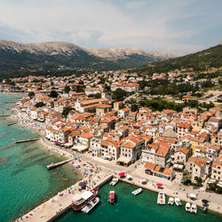 High angle view of townscape by sea against sky