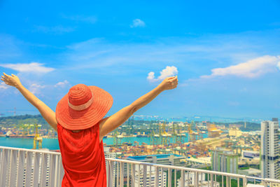 Woman with arms raised standing in city