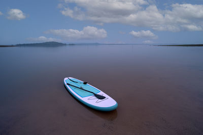 Boat moored on beach against sky