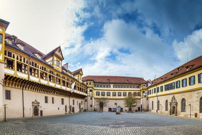 Buildings in city against cloudy sky