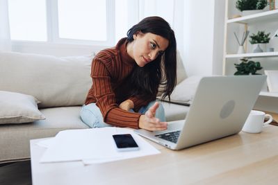 Businesswoman using laptop at desk in office