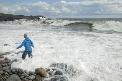 Full length of boy on beach against sky