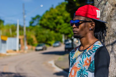 Young woman looking away while sitting on road