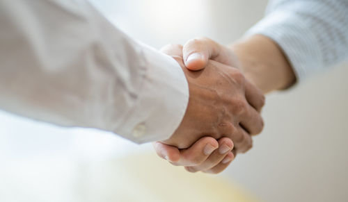 Midsection of doctor giving handshake