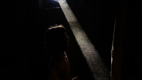 Silhouette person standing against black background