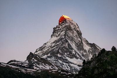 Low angle view of snowcapped mountain against clear sky