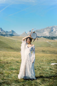 Rear view of woman standing on field