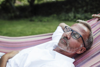 Man with eyeglasses relaxing on hammock