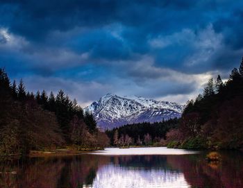 Scenic view of river amidst trees against cloudy sky at glencoe