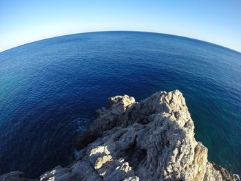 High angle view of rock formation in sea against clear sky