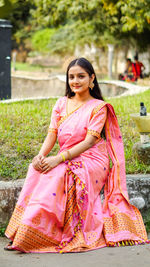 Portrait of smiling young woman sitting outdoors