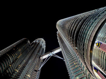 Low angle view of illuminated skyscraper against clear sky at night