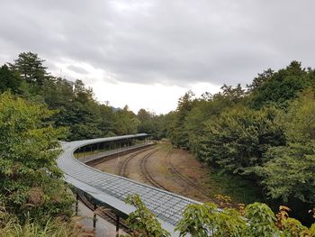 High angle view of road amidst trees against sky