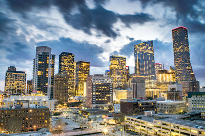 Illuminated buildings in city against sky