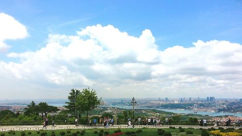 People in city against cloudy sky