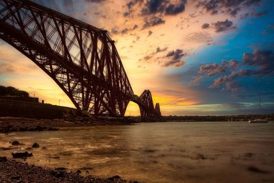 Bridge over sea against cloudy sky