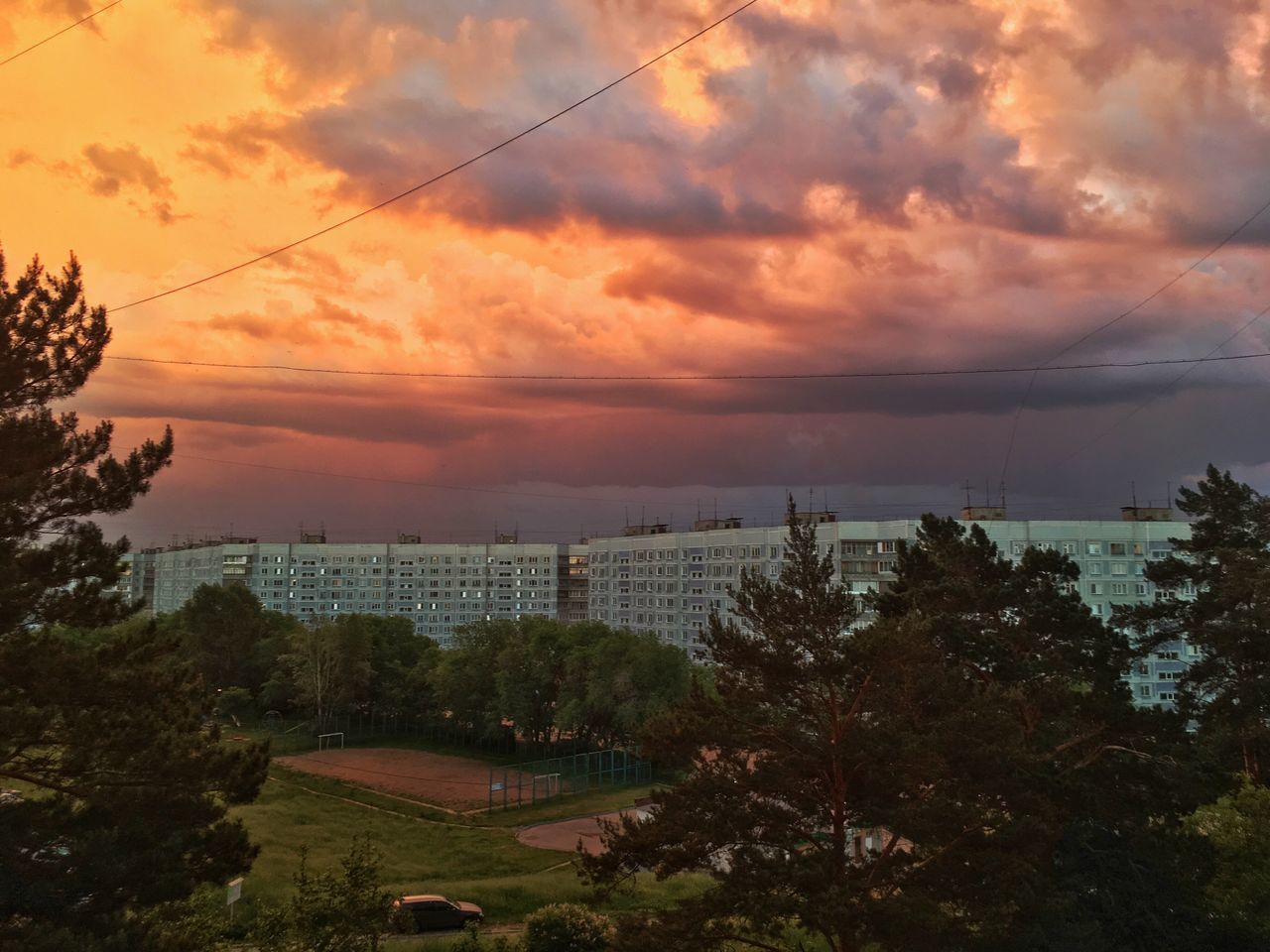 HIGH ANGLE VIEW OF BUILDINGS AGAINST SKY AT SUNSET