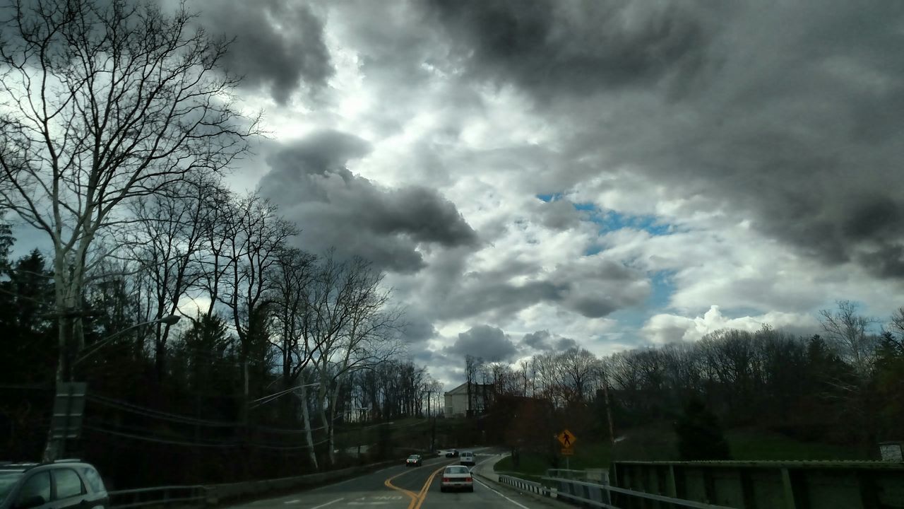 transportation, sky, cloud - sky, tree, car, road, cloudy, land vehicle, mode of transport, the way forward, street, weather, cloud, bare tree, overcast, diminishing perspective, road marking, silhouette, nature, storm cloud