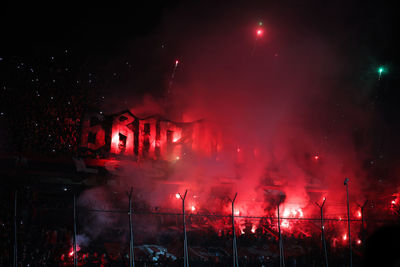 Argentine soccer fans light red flares in the stands of a stadium