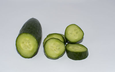 Close-up of green fruits over white background