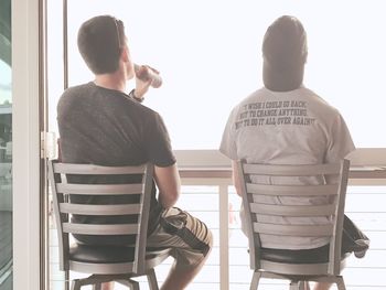 Rear view of men sitting on chair