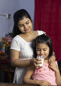 Portrait of mother and daughter drinking