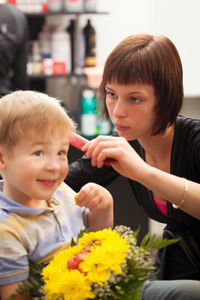 Cute boy having haircut at barber shop