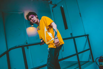 Portrait of young man standing against railing