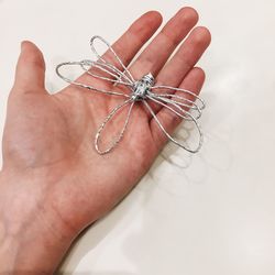 Close-up of hand holding string animal on white background