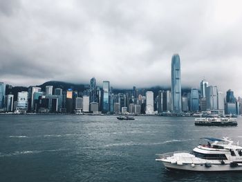 Sea and buildings in city against sky