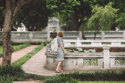Rear view of woman with umbrella walking in park